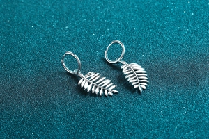 Close-up of S925 sterling silver leaf hoop earrings with moissanite accents