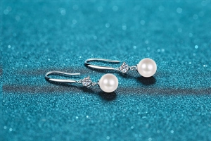 Detailed close-up of 8mm freshwater pearl earrings with 925 silver hooks and moissanite