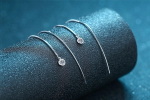 Detail of S925 sterling silver drop earrings featuring moissanite round bezel settings