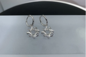 Detail of S925 silver polygon earrings with sparkling moissanite stones and star pendants