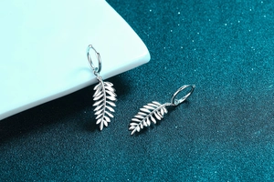 Detailed shot of S925 sterling silver leaf earrings with moissanite accents and polished finish