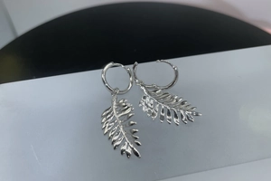 Close-up of S925 sterling silver hoop earrings with intricate leaf pendant detail