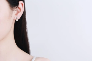 Close-up of S925 silver bow stud earrings with a 6mm white freshwater pearl on model