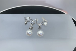 Macro shot of 925 silver mermaid tail earrings with paved crystals and freshwater pearls