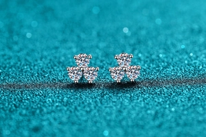 Macro shot of 925 silver clover earrings with three sparkling moissanite stones