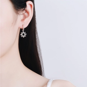 Polished S925 sterling silver snowflake earrings with moissanite crystals worn by a model