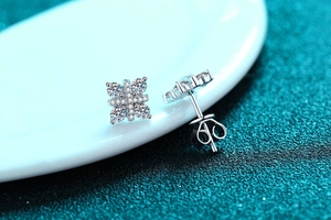 Close-up of 925 sterling silver earrings with cross flower design and moissanite stones