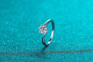 Macro side view of moissanite ring with heart-shaped prongs and twisted band