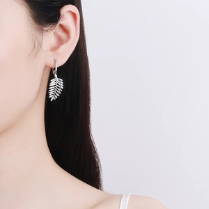 Elegant S925 sterling silver leaf earrings with moissanite stones on female model