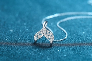 Macro view of sterling silver mermaid tail pendant featuring sparkling moissanite stones