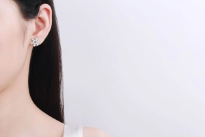 Detailed view of a S925 sterling silver snowflake stud earring worn by a model