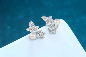 Close-up of S925 silver star earrings featuring freshwater pearls and moissanite