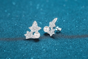 Macro shot of S925 sterling silver star earrings with white pearls and moissanite