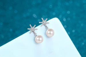 Close-up of S925 silver snowflake earrings featuring glossy freshwater pearls and zircons
