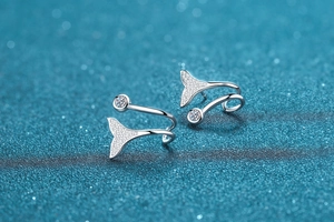 Macro shot of silver mermaid tail earrings with shimmering pavé micro-zirconia stones