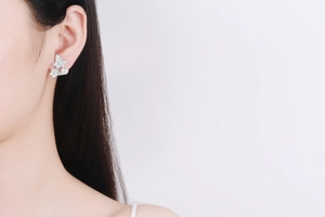 Macro detail of S925 silver star earrings with pavé moissanite and round freshwater pearls