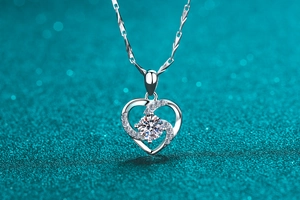 Gros plan d'un pendentif cœur en argent avec pierre taille brillant sur fond bleu pailleté