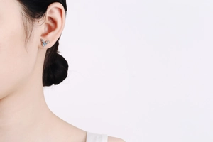 Détail d'une boucle d'oreille bois de cerf en argent avec moissanite bleue sur oreille