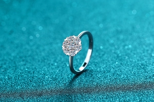 Détail macro de la bague en argent S925 avec motif fleur en moissanite sur fond bleu luxe