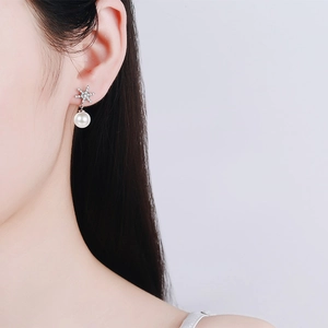 S925 sterling silver snowflake earrings with 8mm freshwater pearls on female model