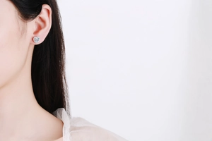 Détail de la boucle d'oreille cœur en argent 925 avec pavé de moissanite sur le mannequin