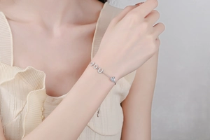 Détail d'un bracelet en argent S925 ajustable avec lettres YOU et cœur bleu