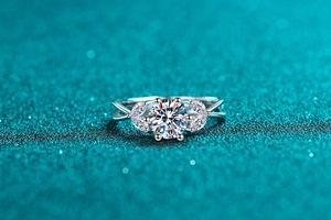 Macro shot of 1 carat moissanite ring with leaf-shaped side stones and twisted silver band