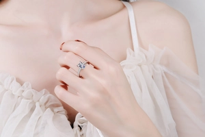 Close-up of S925 silver ring with emerald-cut moissanite stone on a model hand