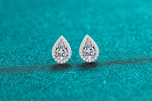 Detailed macro view of pear-shaped moissanite stud earrings with halo diamond accents