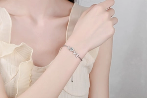 Gros plan du bracelet LOVE en argent S925 avec moissanite cœur sur poignet féminin