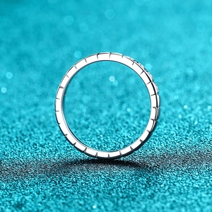 Modern S925 silver moissanite ring with vertical carved texture on a teal bokeh background
