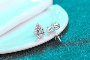 Macro shot of pear-shaped moissanite silver stud earrings with classic halo setting