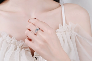 Close-up of S925 silver wedding ring with round moissanite and leaf-shaped diamond details