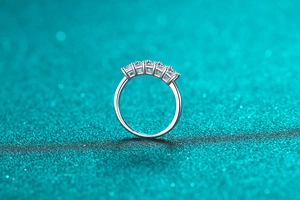 Macro shot of 925 silver ring featuring five emerald cut moissanite stones in four-prong setting