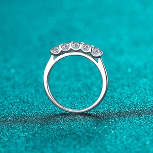 Classic S925 sterling silver ring with five round moissanite stones in a row on blue background