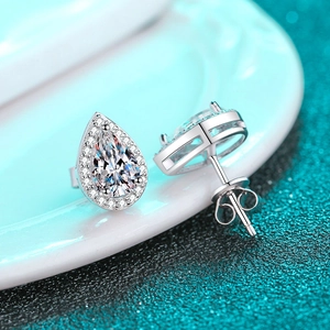 Elegant pair of pear-shaped halo stud earrings in S925 sterling silver on white ceramic