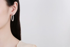 Détail de créoles en argent sterling S925 avec moissanite pavée portées sur un mannequin