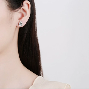 Elegant S925 sterling silver pear cut moissanite stud earrings worn by a model