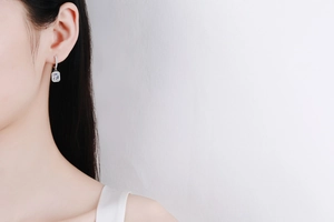 Close-up of S925 silver earring with radiant cut blue gemstone and zircon halo