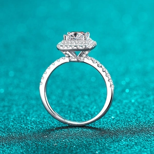 Bague élégante en argent S925 avec diamant princesse et halo sur fond bleu texturé chic