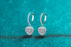 Macro shot of S925 silver heart earrings featuring sparkling moissanite and pave diamonds