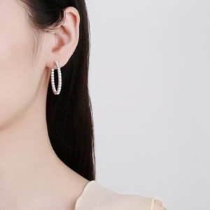 Élégantes boucles d'oreilles ovales en argent 925 avec moissanite sur modèle féminin