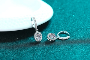 Macro detail of S925 sterling silver drop earrings with oval halo moissanite and stones