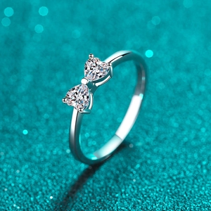 Polished S925 silver ring featuring a bow tie design with two heart-shaped moissanite stones