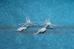 Detail of 925 sterling silver bow earrings with moissanite fringe drops and cubic zirconia