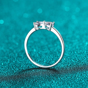 Elegant S925 sterling silver ring with two heart-shaped moissanite stones on blue background