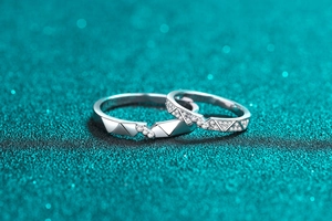 Macro shot of geometric S925 sterling silver couple rings with micro-pave moissanite detail
