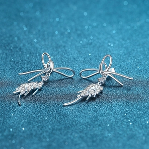 925 sterling silver bow earrings with moissanite tassels on a blue glitter background