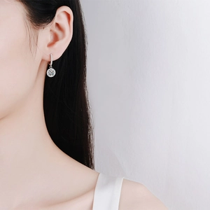 Boucles d'oreilles créoles halo en argent S925 et moissanite portées par un modèle