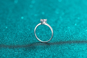 Macro shot of silver S925 heart moissanite ring with four-prong setting and sparkles